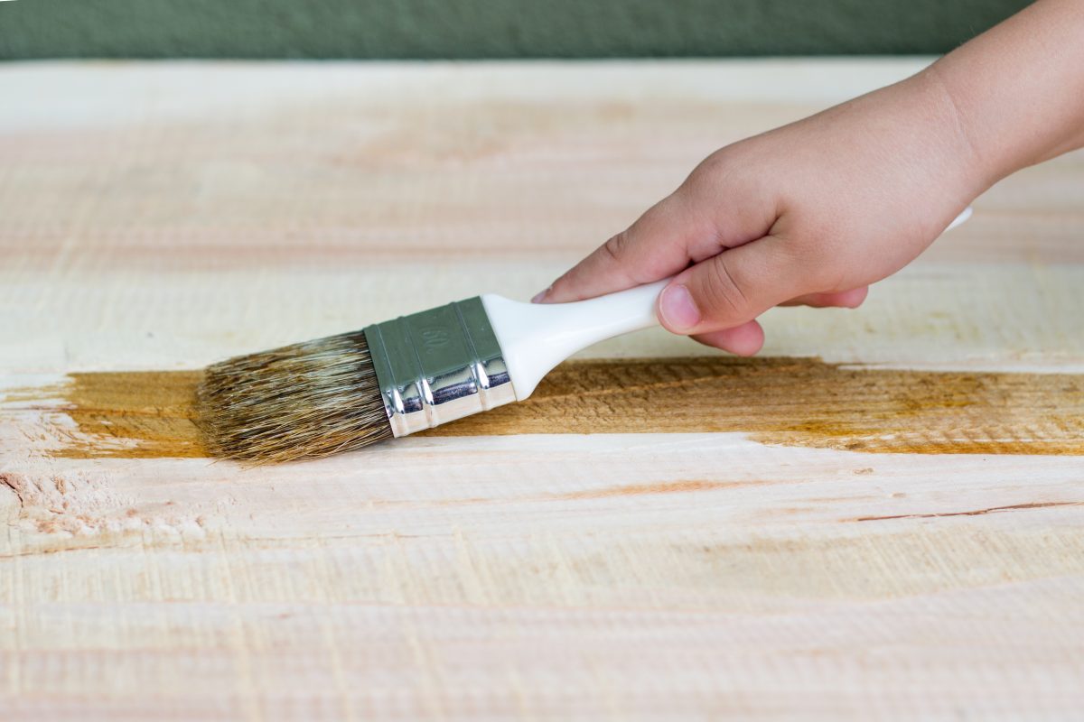 kid-hand-varnishing-wooden-shelf-using-paintbrush-1200x800.jpg